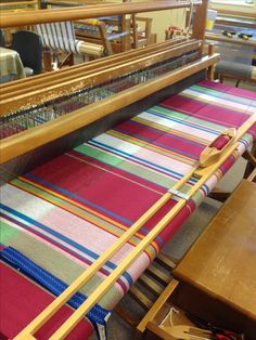 an old weaving loom is being worked on by someone in a shop or office