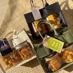 several jars filled with food sitting on top of a table next to bags and tags