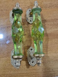 two green glass door handles on a wooden surface