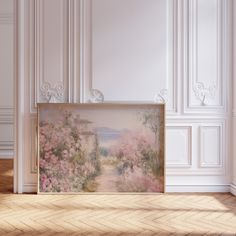 an empty room with a painting on the wall and wood flooring in front of it