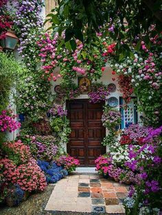 a door is surrounded by flowers and greenery