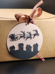 a christmas ornament on top of a cardboard box with a ribbon around it