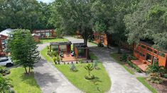 an aerial view of two tiny homes in the woods with cars parked outside and trees surrounding them