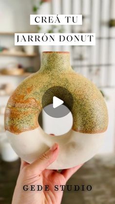 a hand holding a vase with the words crea tu jarron donut on it