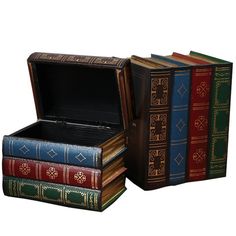 three books are stacked on top of each other in an open box with the lid closed