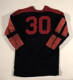 a hockey jersey with the number 30 on it is hanging up against a white wall