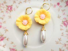 "These beautiful hibiscus earrings were created with brass lace settings adorned with yellow and pink hibiscus flowers and Vintage teardrop glass pearls. These floral earrings hang beautifully from the ear and measure 2 1/2 inches in length and measure 3/4 inches in width at widest point. These earrings make the \"perfect gift\" for your mom, sister, daughter, friend, girlfriend, wife or bridesmaids....She will truly love these and treasure them for many years to come. ~All of my listings are ha Elegant Yellow Dangle Flower Earrings, Elegant Yellow Flower Earrings For Wedding, Elegant Yellow Flower Shaped Earrings, Elegant Yellow Flower-shaped Earrings, Yellow Pearl Drop Jewelry Gift, Gift Yellow Pearl Drop Jewelry, Handmade Yellow Flower Earrings For Wedding, Yellow Flower Drop Earrings For Wedding, Yellow Flower-shaped Party Earrings