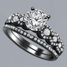 an engagement ring set with two matching bands and a round diamond center surrounded by smaller diamonds