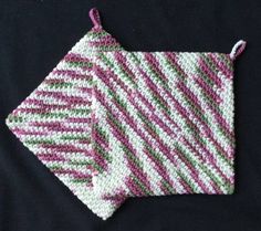 two crocheted pink and green stripes on a black background, one is folded in half