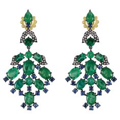 Indulge in the opulence of our Victorian 19.68 Cttw. Emerald, Blue Sapphire, and Diamond Dangle Earrings—a testament to the timeless allure of precious gemstones and exquisite craftsmanship. The drop of these earrings is a mesmerizing assembly of round and oval emeralds, gracefully connected by nodes of deep blue sapphires in meticulous black prong settings. The leaves, delicately crafted in black rhodium and adorned with diamonds, add a touch of glamour to the top of the drop, creating a captiv Luxury Blue Chandelier Earrings For Formal Occasions, Luxury Victorian Round Earrings, Luxury Round Sapphire Diamond Earrings, Edwardian Sapphire Earrings, Emerald Earrings 1stdibs, Luxury Multi-stone Sapphire Earrings, Emerald Blue, Sapphire And Diamond Earrings, Diamond Dangle Earrings