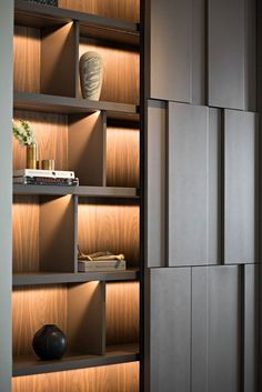 a book shelf filled with books and a vase on top of it's shelves