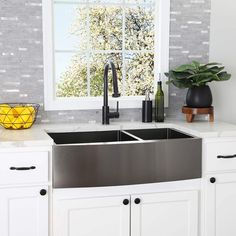 a stainless steel kitchen sink in front of a window