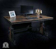 a desk with a computer on top of it and a flower in front of the monitor