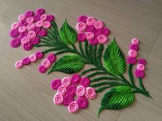 some pink flowers and green leaves on a table