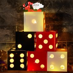 dices are stacked on top of each other in front of a wall with lights