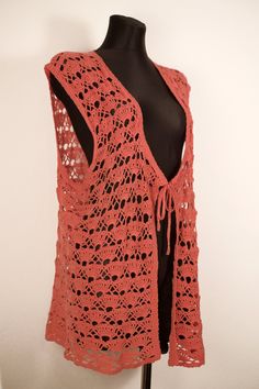 an orange crocheted shawl on a mannequin