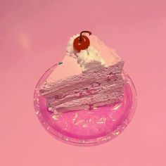 a piece of cake sitting on top of a pink plate with a cherry on top