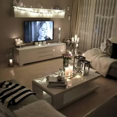 a living room filled with furniture and a flat screen tv on top of a wooden table