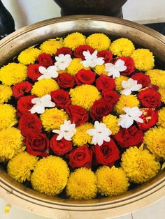 a bowl filled with yellow and red flowers