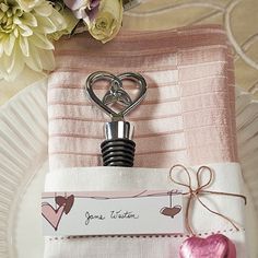 a pink napkin with a bottle opener attached to it on top of a white plate