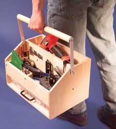 a man holding a tool box with tools in it and his foot on the ground