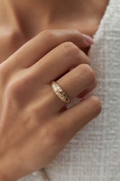 a woman's hand wearing a gold ring