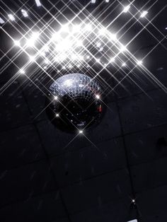 a disco ball with lights shining down on it's sides and the floor below