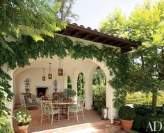 an outdoor dining area with potted plants and trees