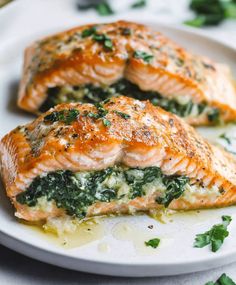 two salmon fillets with spinach on a white plate