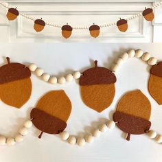 felt acorns and white beads are hanging on the wall