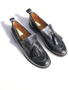 Slip into luxury with these Le Sapeur loafers from our L’Artisane collaboration. Made from locally-sourced snakeskin leather, they were skillfully constructed and dyed entirely by Senegalese hands– resulting in the rich black patina you see here. The tassels add a distinguished touch. Slips onHeel Height: 2 in/5 cmHandcrafted in Senegal Black Loafers, Black Slip Ons, Holiday Collection, Snake Skin, Patina, Heel Height, Tassels, Loafers, Slip On