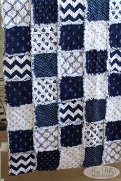 a blue and white crocheted blanket hanging on a wall next to a window