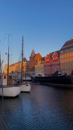 two boats are docked in the water next to some buildings