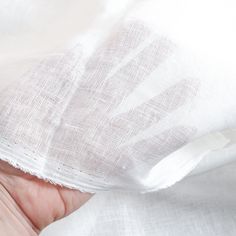 a hand holding a piece of white fabric