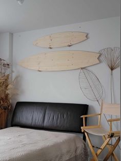 two surfboards mounted to the wall above a bed in a room with a black leather chair