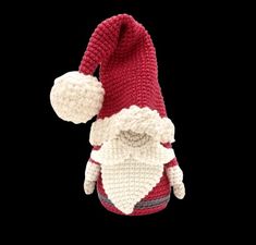 a crocheted santa clause hat and mitten on a black background with copy space