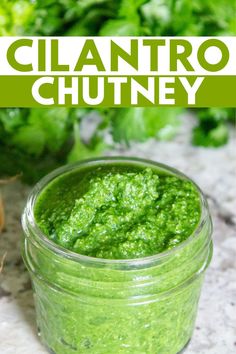 a jar filled with cilantro chutney sitting on top of a counter