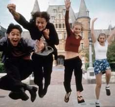 four people jumping in the air with their hands up