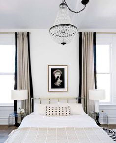 an instagram photo of a white bedroom with black and white decor on the walls