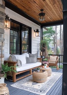 the porch is decorated with wicker furniture and outdoor rugs, along with potted plants