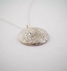 a fingerprint pendant is shown on a white surface