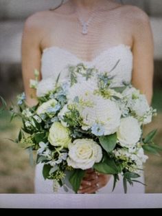 a woman holding a bouquet of flowers in her hands