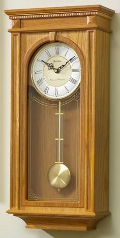 a wooden clock mounted to the side of a wall