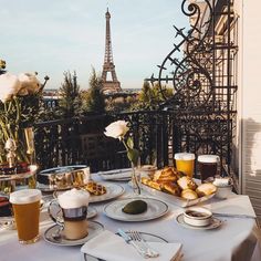 a table with food and drinks on it in front of the eiffel tower