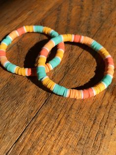 This bracelet is called sunset breeze. It includes teal, yellow, orange, light orange, and white clay beads. If you have any questions message me. Sunset Clay Bracelet, Orange Heishi Beads Bracelets For Beach, Handmade Orange Heishi Beads Friendship Bracelets, Sunrise Clay Bead Bracelet, Sunset Clay Bead Bracelet, Orange Clay Bead Bracelets, Playful Orange Bracelets For Beach, Orange And Blue Bracelet, Sunset Bracelet