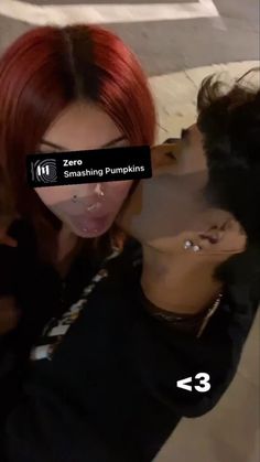 two people with red hair are kissing and one person is sticking out her tongue to the camera