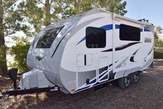 an rv is parked in the woods near some trees