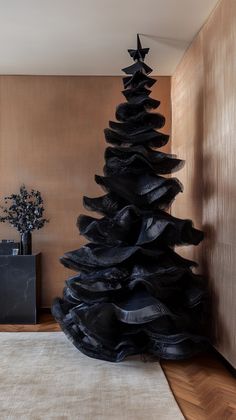 a black christmas tree sitting on top of a wooden floor