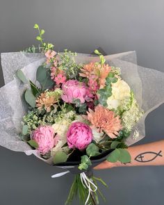 a person holding a bouquet of flowers in their hand