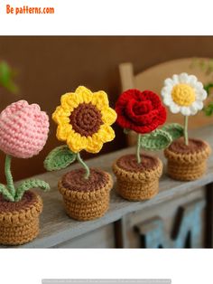 crocheted flowers are placed in small pots